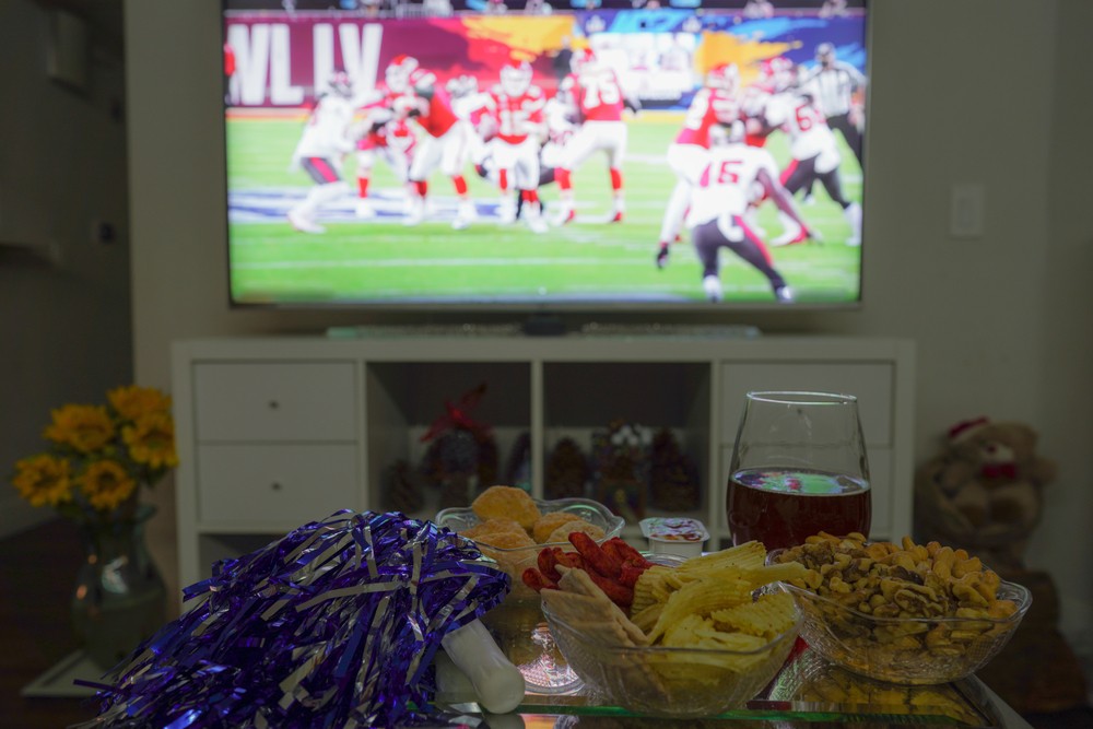 Super Bowl game on TV at home with snacks and beer and Pom-Pom