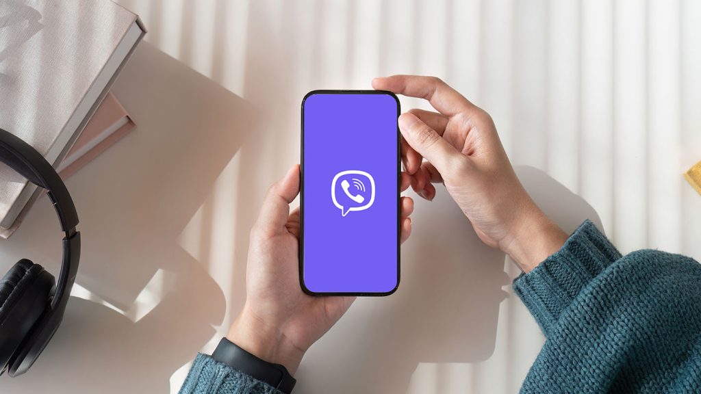 Top view mockup image of a woman holding mobile phone with blank white screen while sitting